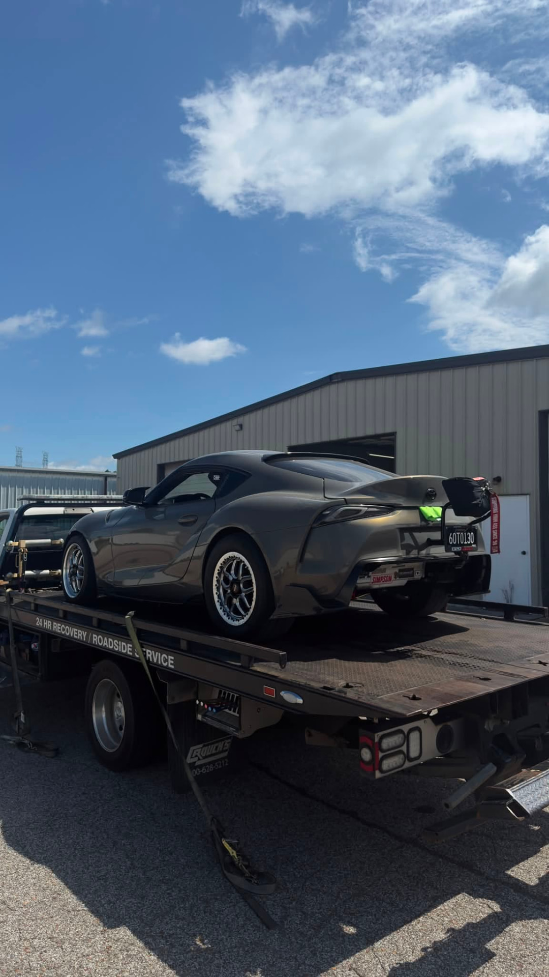 Smiths Towing flatbed tow truck hauling a sports car after a service call